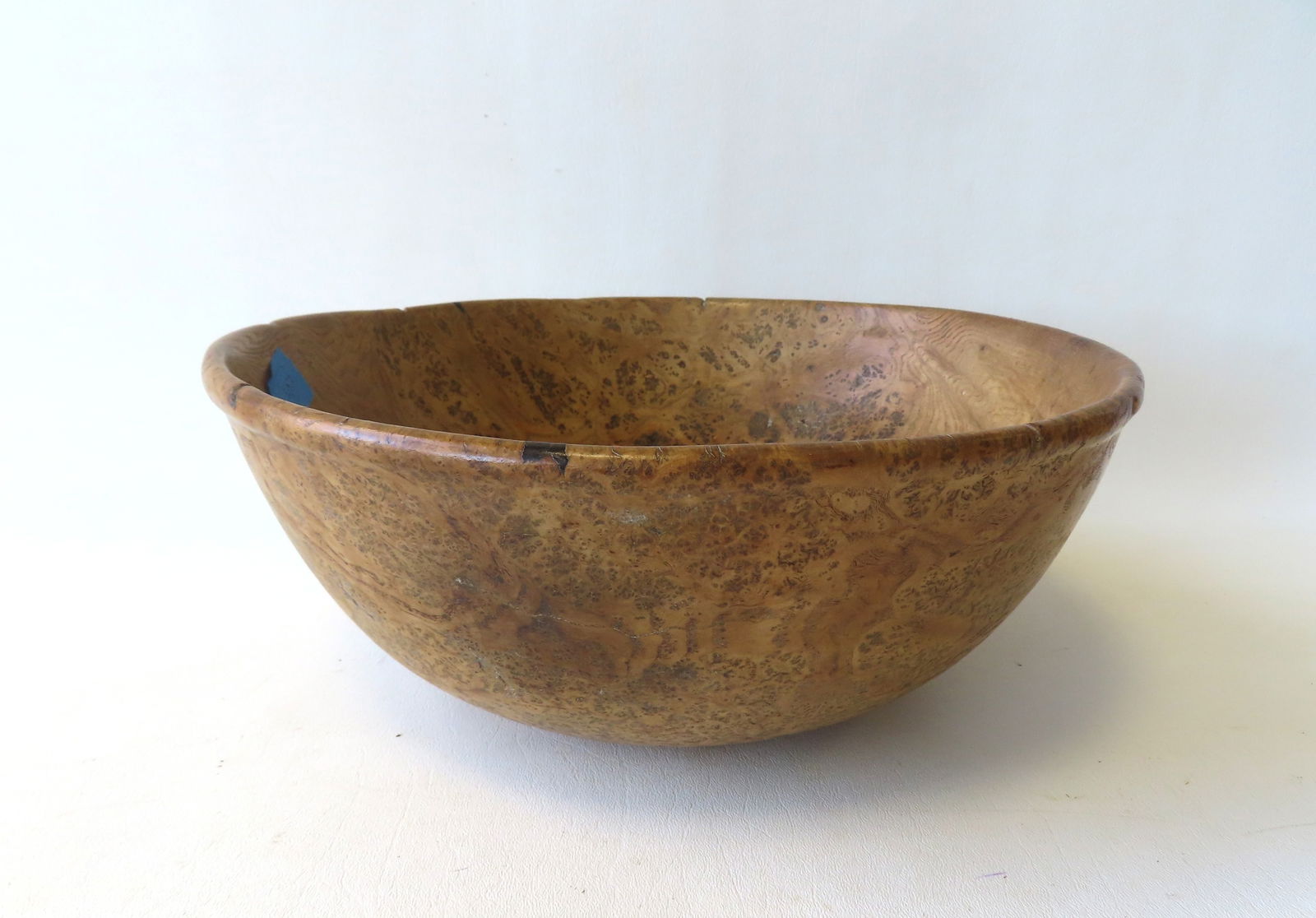 A very fine ash burl bowl with shape rim, early 19th century. Natural indentations in rim and: A very fine ash burl bowl with shape rim, early 19th century. Natural indentations in rim and appears in very good condition. Measures 12 1/2" diameter x 5 1/4"H. Provenance: From the Marni Bakst and