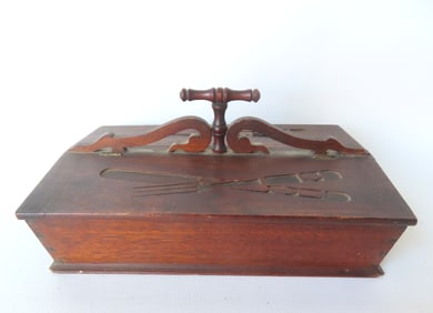 A black walnut cutlery box with shaped handle and 2 lidded compartments, each with incised