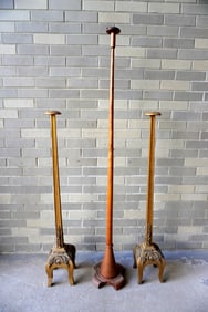 Three carved wooden floor standing bonnet holders including: Two matching gilded wooden stands in