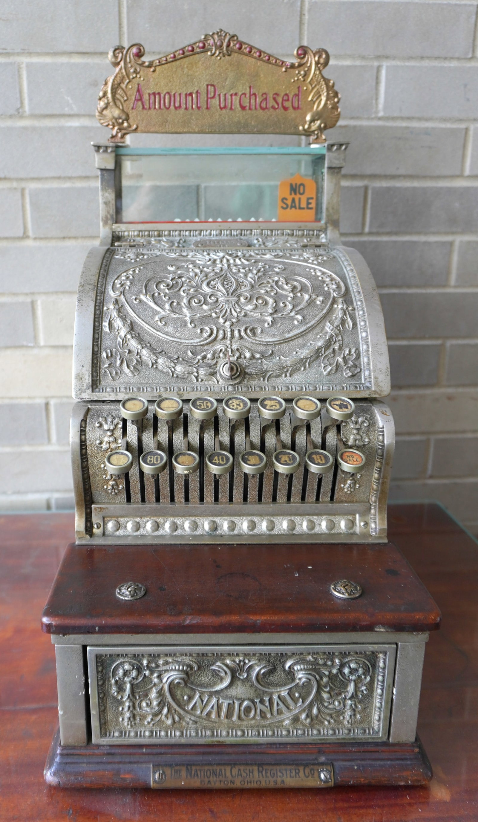 A "National" nickel plated cash register, Model 313, signed "The National Cash Register Co. Dayton: A "National" nickel plated cash register, Model 313, signed "The National Cash Register Co. Dayton Ohio U.S.A.", circa 1914. The register has 15 keys from 5 cents to $1, mahogany wood coin shelf, and 
