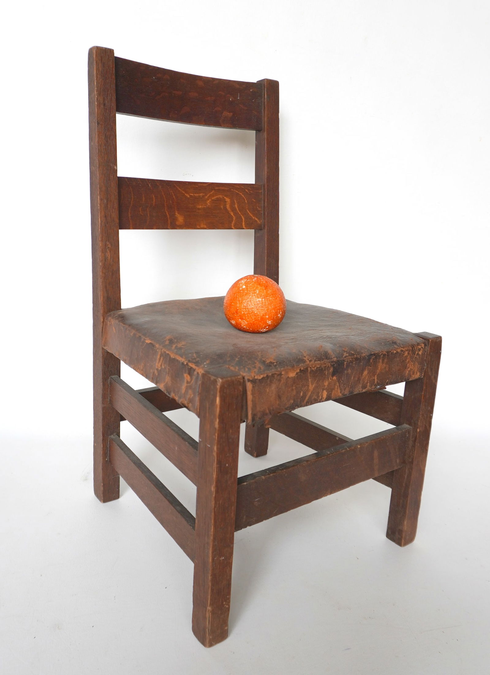 A signed Charles Stickley ("Chas. Stickley" script signature) slat back child's oak arm chair with: A signed Charles Stickley ("Chas. Stickley" script signature) slat back child's oak arm chair with original leather seat. Original finish and seat and in good condition. Measures 13 1/4" x 12 1/2"D x