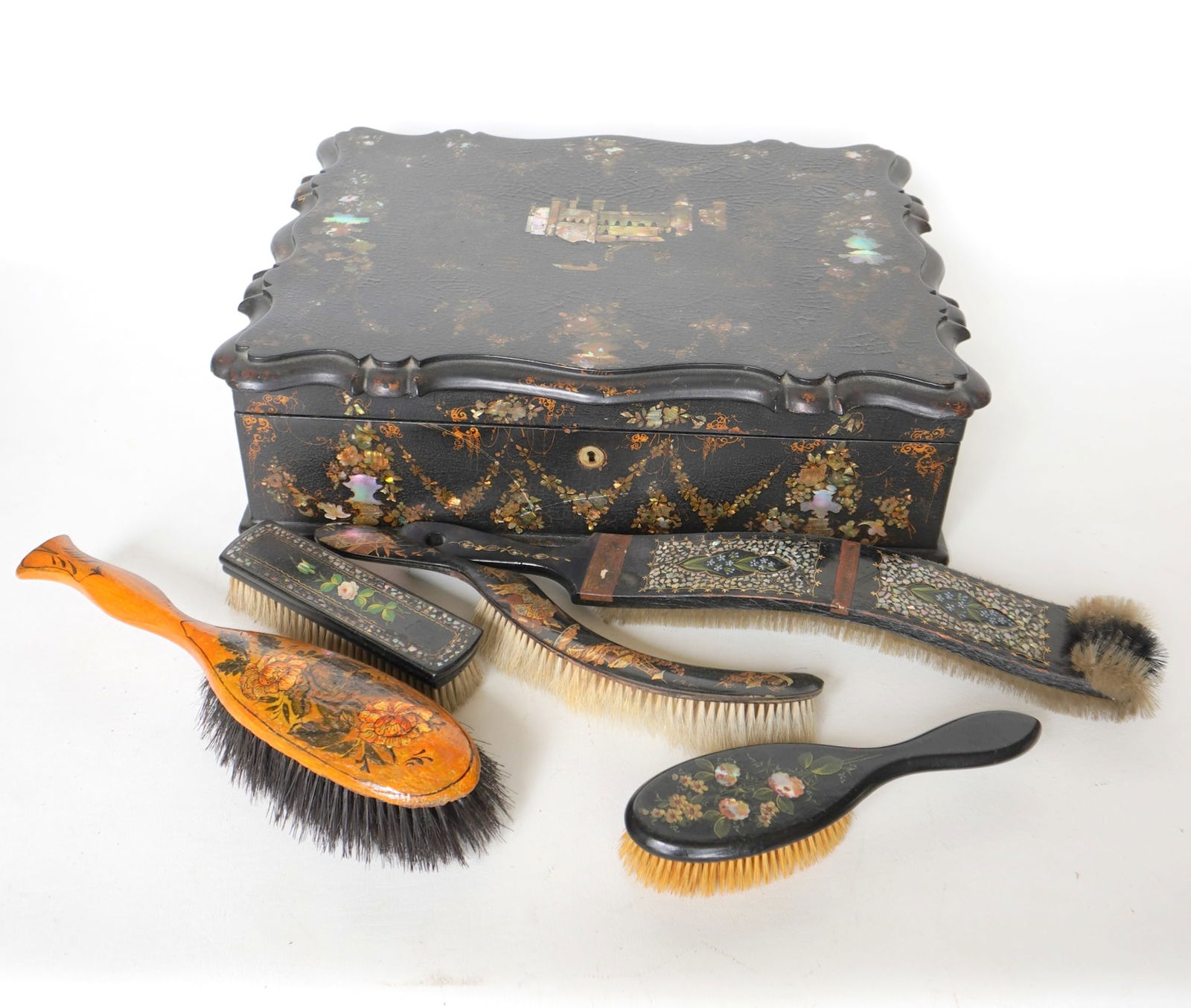 A lovely lady's paper mache traveling box together with 5 lacquered hand painted brushes. The: A lovely lady's paper mache traveling box together with 5 lacquered hand painted brushes. The traveling box with fitted interior, appears to be used for writing and sewing and possibly jewelry. The li