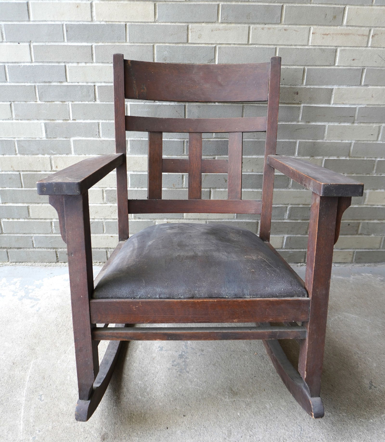 A Mission oak rocker having horizontal and vertical slats with original paper label signed: A Mission oak rocker having horizontal and vertical slats with original paper label signed "Sheboygan Chair Co. / Wisconsin", early 20th century. Appears to retain original finish and original leather