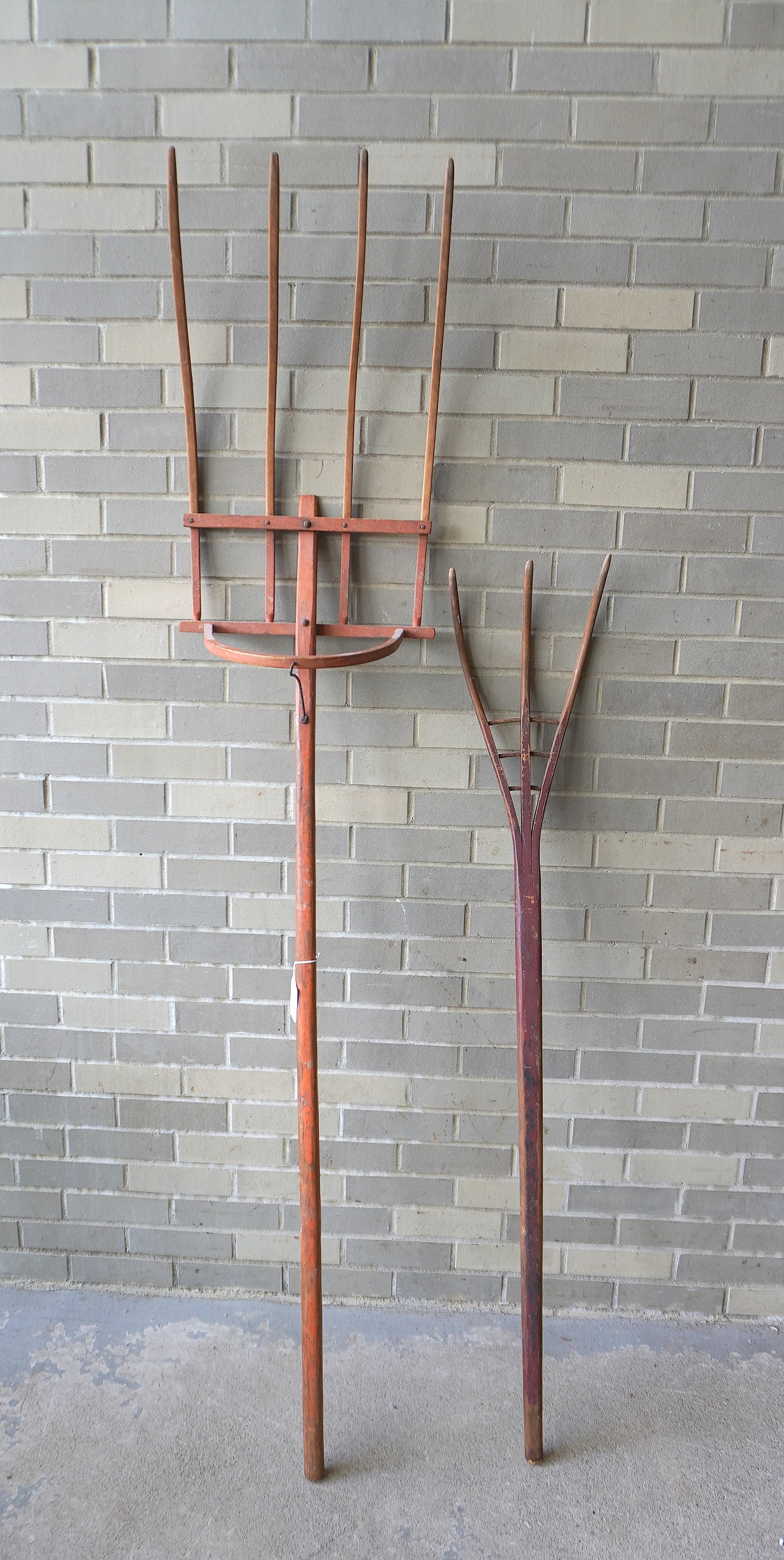Two 19th century hand made wooden farming tools in original paint, including: Hay fork with 4 tines: Two 19th century hand made wooden farming tools in original paint, including: Hay fork with 4 tines in salmon paint - measures 78"L x 16 1/2"W x 10"D - very good condition; and a 3 tine hay fork in br