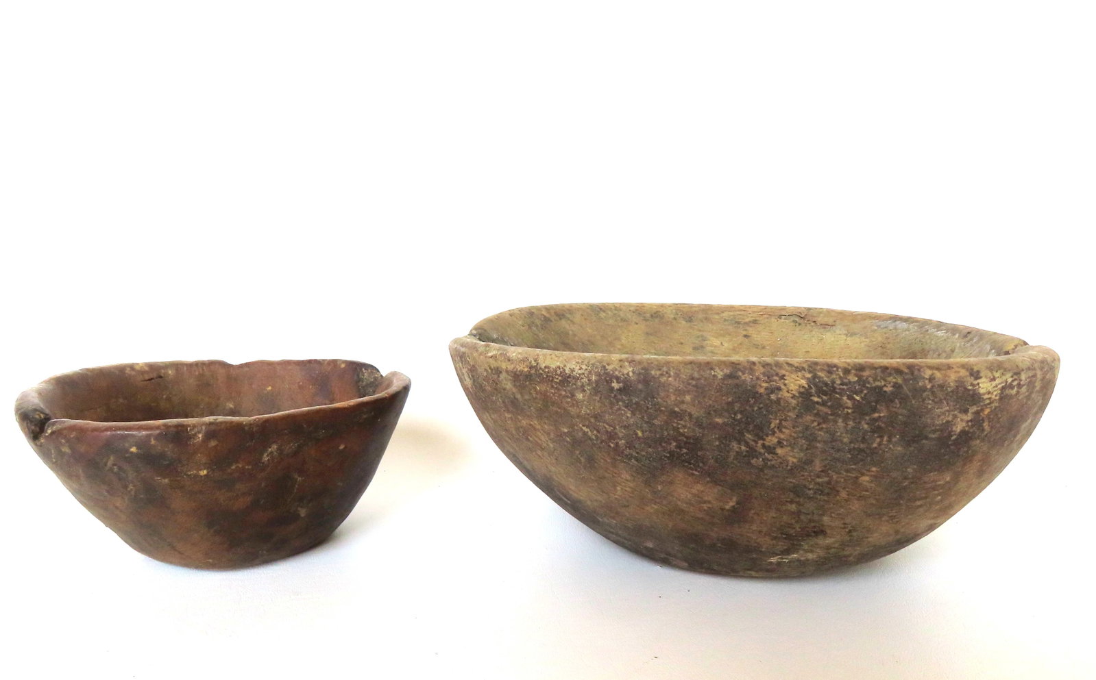 Two primitive burlwood bowls, 18th century - both with extensive use wear and some very old edge: Two primitive burlwood bowls, 18th century - both with extensive use wear and some very old edge losses. The smaller measures 7"L x 5 1/2"W x 3 1/8"H and the larger 10 3/4" diameter x 4 3/8"H. Provena