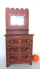 A lovely child's doll 3 drawer chest with attached mirror with scalloped crest, in original darkened