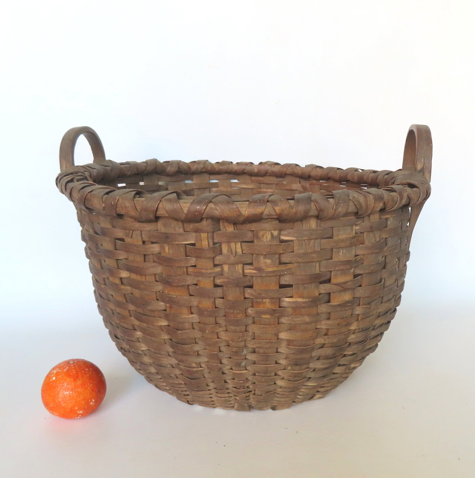 A good Taghkanic field basket with carved looped handles on each side, pushed up bottom and: A good Taghkanic field basket with carved looped handles on each side, pushed up bottom and crisscrossed rim, mid 19th century - all original, 2 small breaks in edge of base hardly noticeable, otherwi