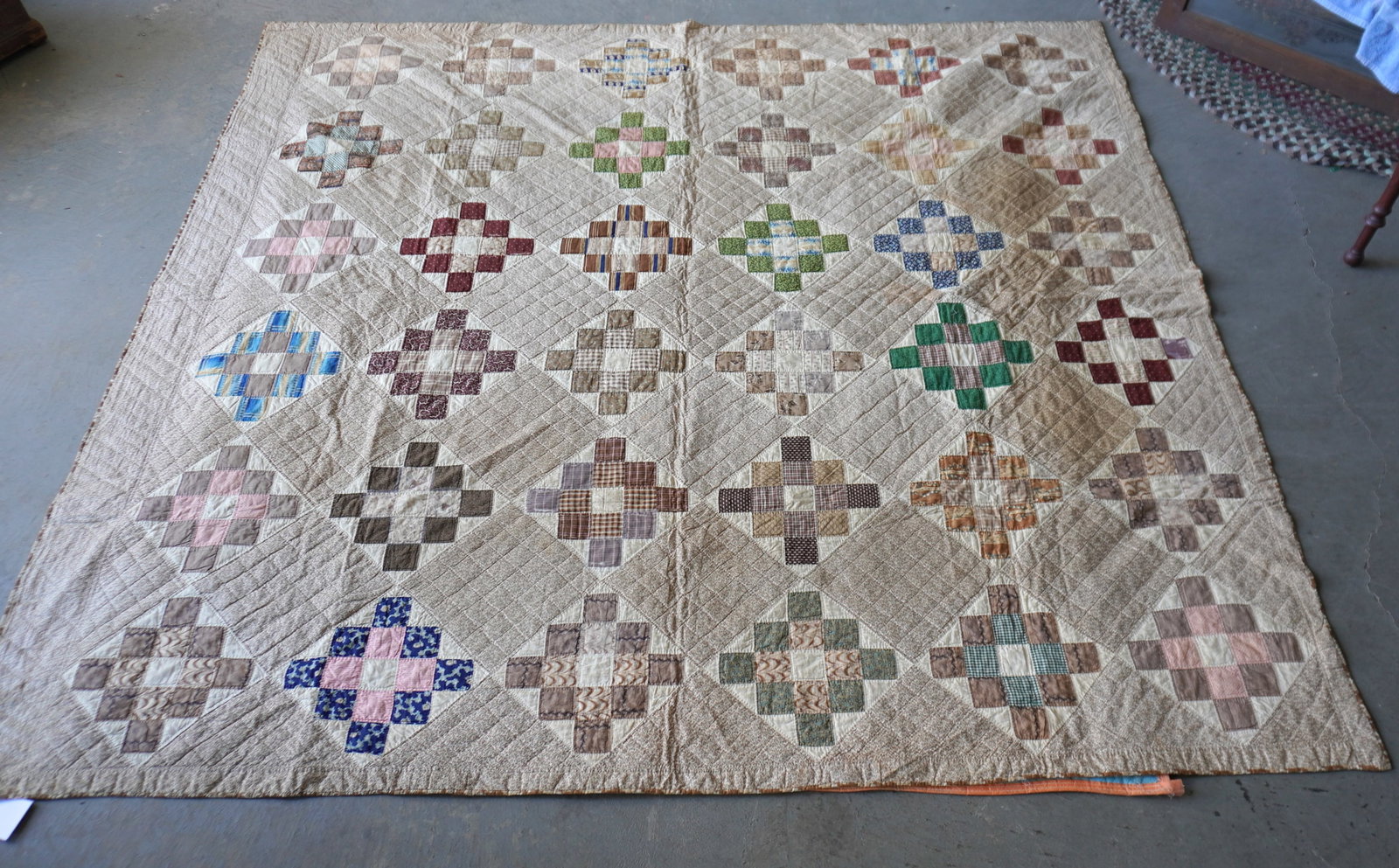 A very fine early patchwork quilt in the 12 Patch Square Block pattern with a triangular border, all: A very fine early patchwork quilt in the 12 Patch Square Block pattern with a triangular border, all hand sewn, mid to late 19th century - small stain in one corner, else very good condition. Measures