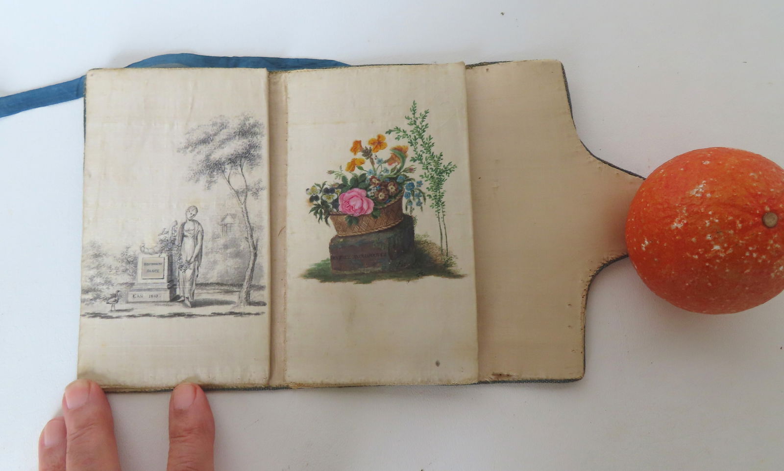 A French folding silk wallet (or letter holder), with 2 compartments. The compartment on the left: A French folding silk wallet (or letter holder), with 2 compartments. The compartment on the left with painting on silk, memorial scene titled on stone "Recconois Sance l'an 1810 (translates - Recogni