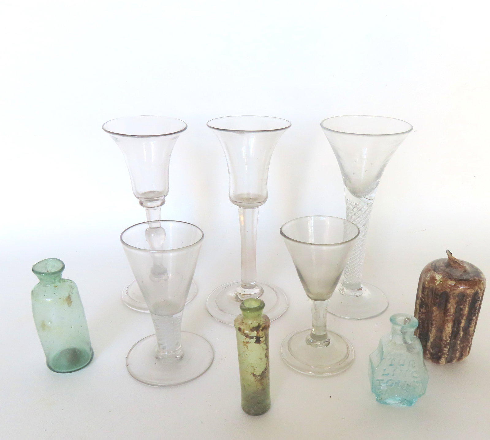 A grouping of 9 early glassware collectibles including: 5 hand-blown wines, 2 with twisted stems,: A grouping of 9 early glassware collectibles including: 5 hand-blown wines, 2 with twisted stems, all with open pontils and non-matching - the largest 6 1/4"H - the smallest with twisted stem has a ve