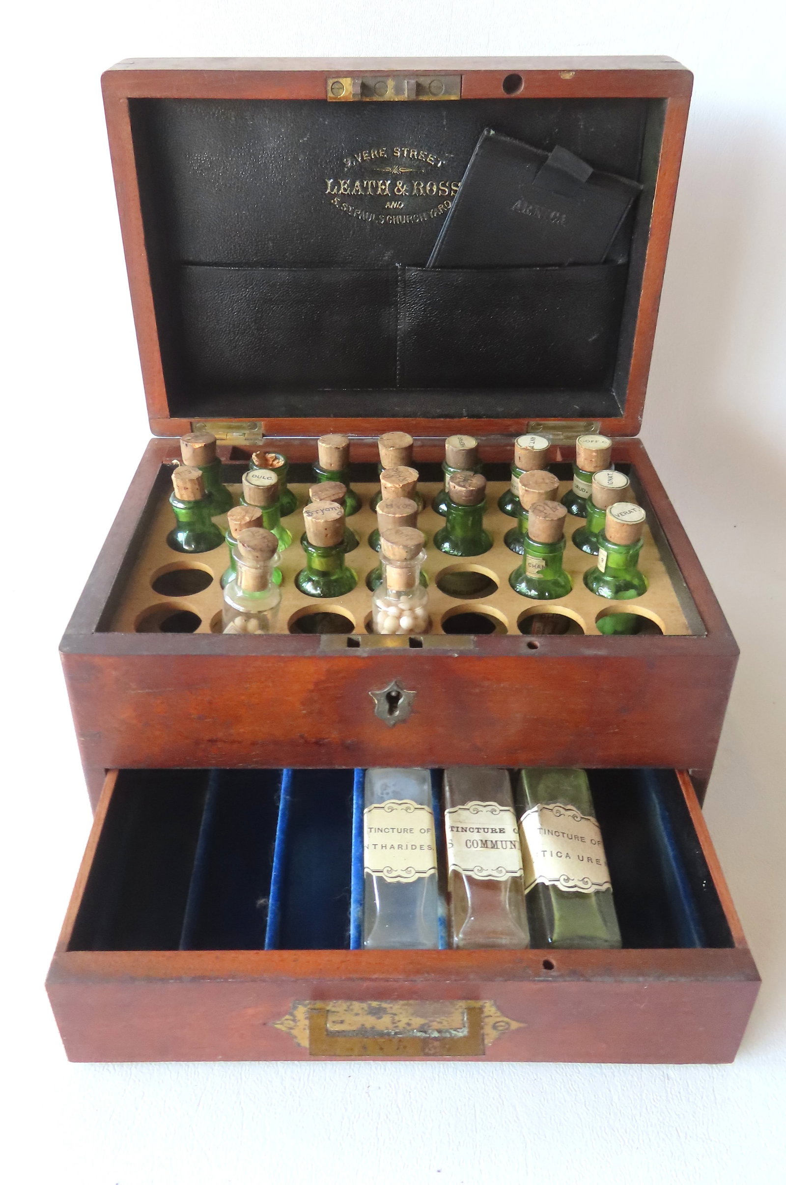 A signed "Leath & Ross" English mahogany homeopathic medicine chest containing 21 small bottles of: A signed "Leath & Ross" English mahogany homeopathic medicine chest containing 21 small bottles of various pills in the top section, and 3 of the same in lower drawer, 19th century. All in very good c