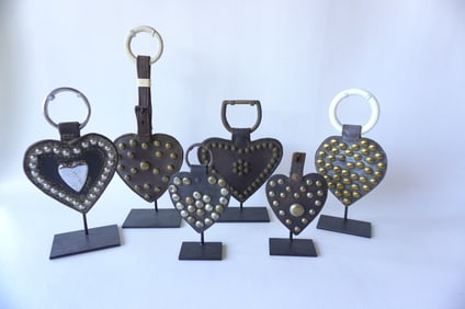 Grouping of 6 leather heart shaped horse harness decorations, all with applied brass and silver