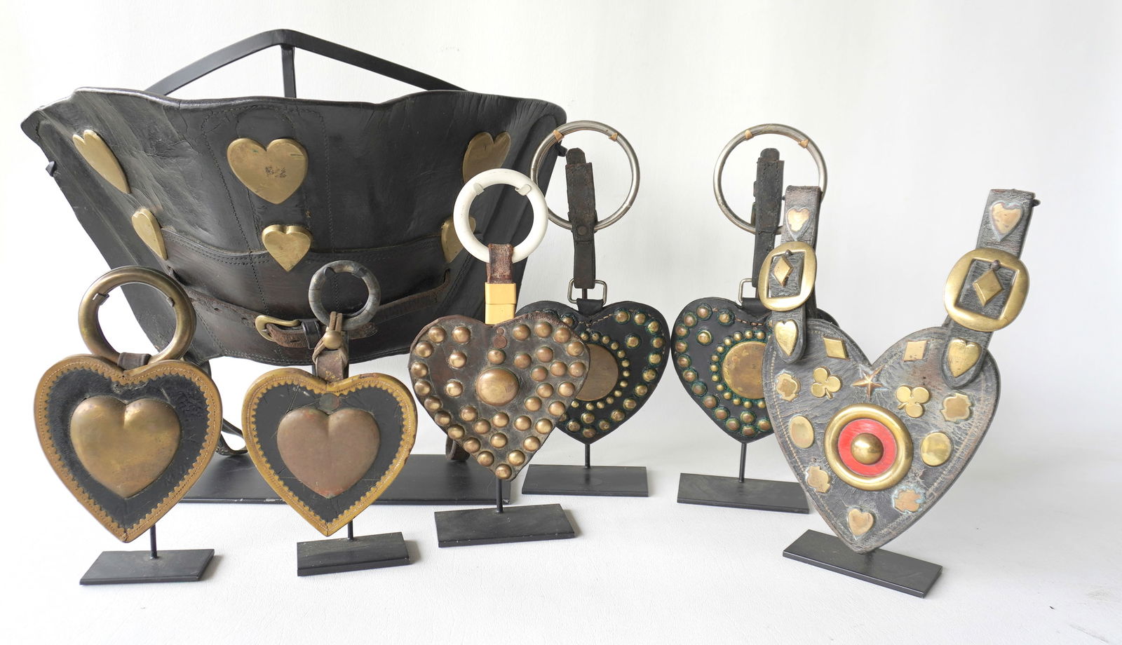 Grouping of 6 leather heart shaped horse harness decorations, all with applied brass ornaments: Grouping of 6 leather heart shaped horse harness decorations, all with applied brass ornaments conforming to the shape of the heart. Two decorated with large brass hearts in the center, 3 decorated wi