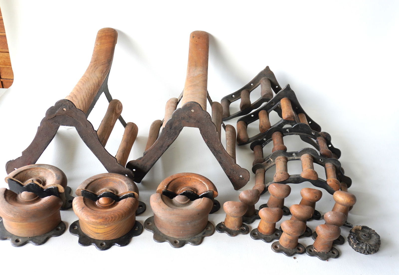 Grouping of 22 vintage iron and oak harness and bridle holders and 4 cast iron ornamental rosettes.: Grouping of 22 vintage iron and oak harness and bridle holders and 4 cast iron ornamental rosettes. The smallest tack pieces measure 3"L and the largest, the saddle holders, measure 19 1/2"L x 12"W x