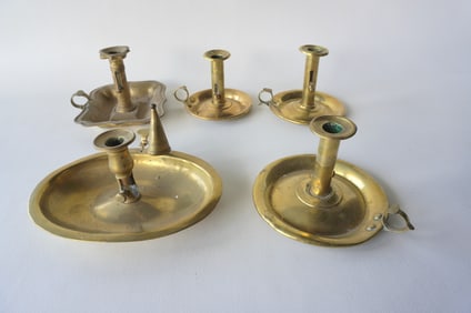 Grouping of 5 brass chamber sticks, one with candle snuffer, several with small dents, otherwise all