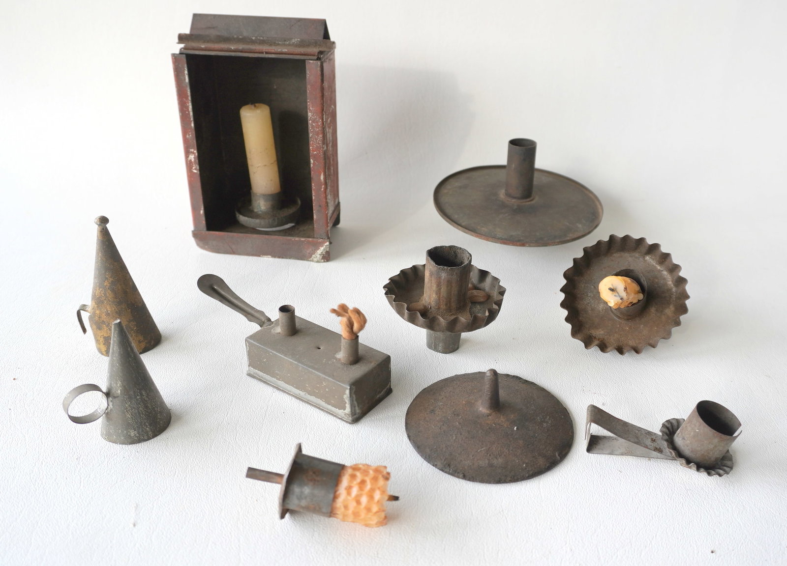 Grouping of tin candle and fat burning lamps, all late 18th to mid 19th century and in good: Grouping of tin candle and fat burning lamps, all late 18th to mid 19th century and in good condition. The largest, a candle dark room light in original red paint (worn) - missing glass insert - measu