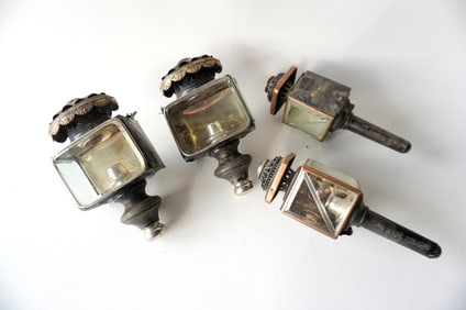 Two matched pairs of coach lights, 19th century. The smaller pair has dents in the silver finial on