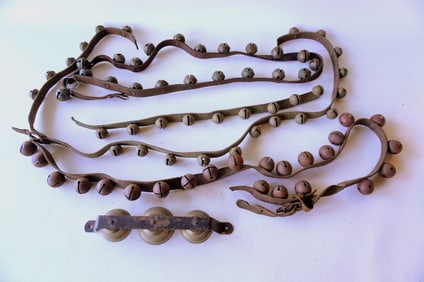 A grouping of incomplete sleigh bells with straps and 1 set of 3 carriage bells. See photos for more