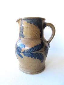 Stoneware pitcher heavily decorated with cobalt blue leaves and flowers on all sides - cracks and