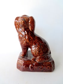 A Bennington stoneware seated Spaniel in brown glaze, mid 19th century, small chips on the underside