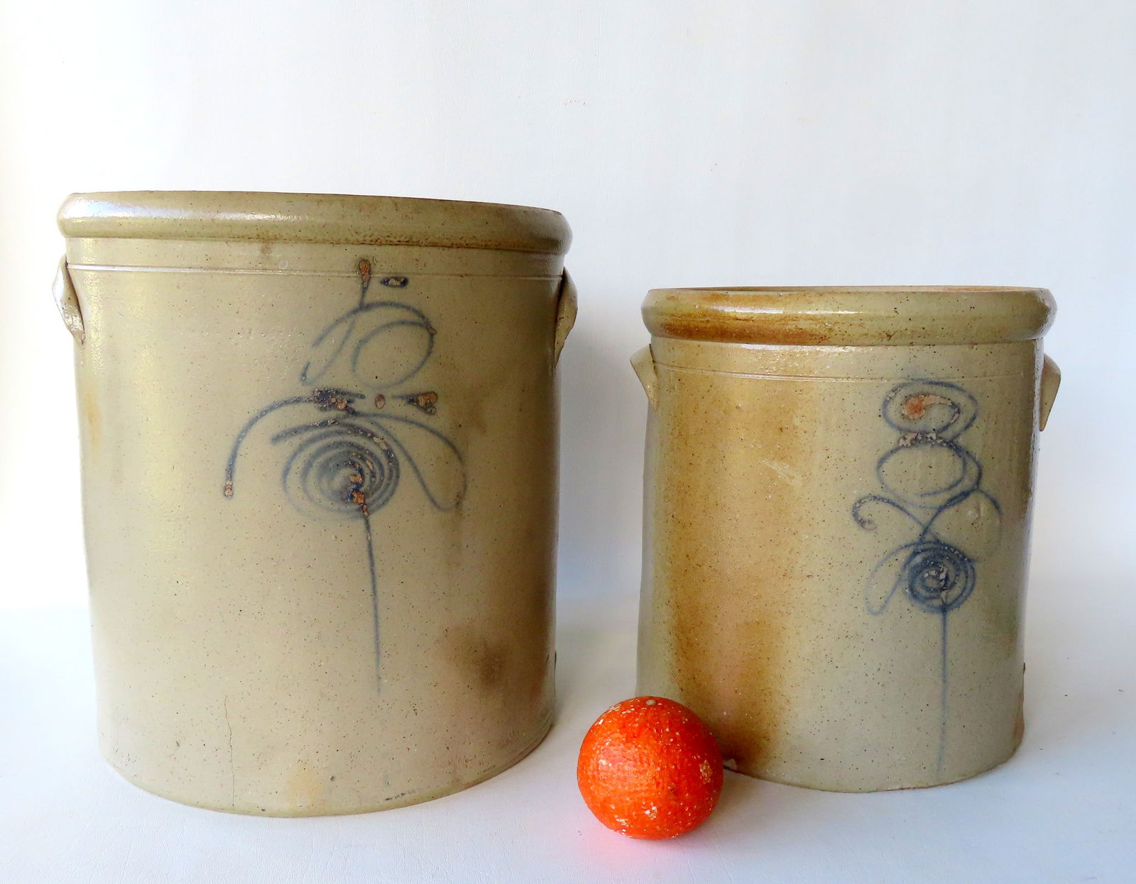 Two stoneware crocks, 3 gallon and 5 gallon, both with cobalt blue markings. The largest measures 12: Two stoneware crocks, 3 gallon and 5 gallon, both with cobalt blue markings. The largest measures 12 3/4"H x 11 1/4". The 5 gallon with small hairline extending from side of base, else both in very go