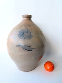 A stoneware ovoid jug, unmarked but either 3 or 4 gallon, decorated with a cobalt blue flower on