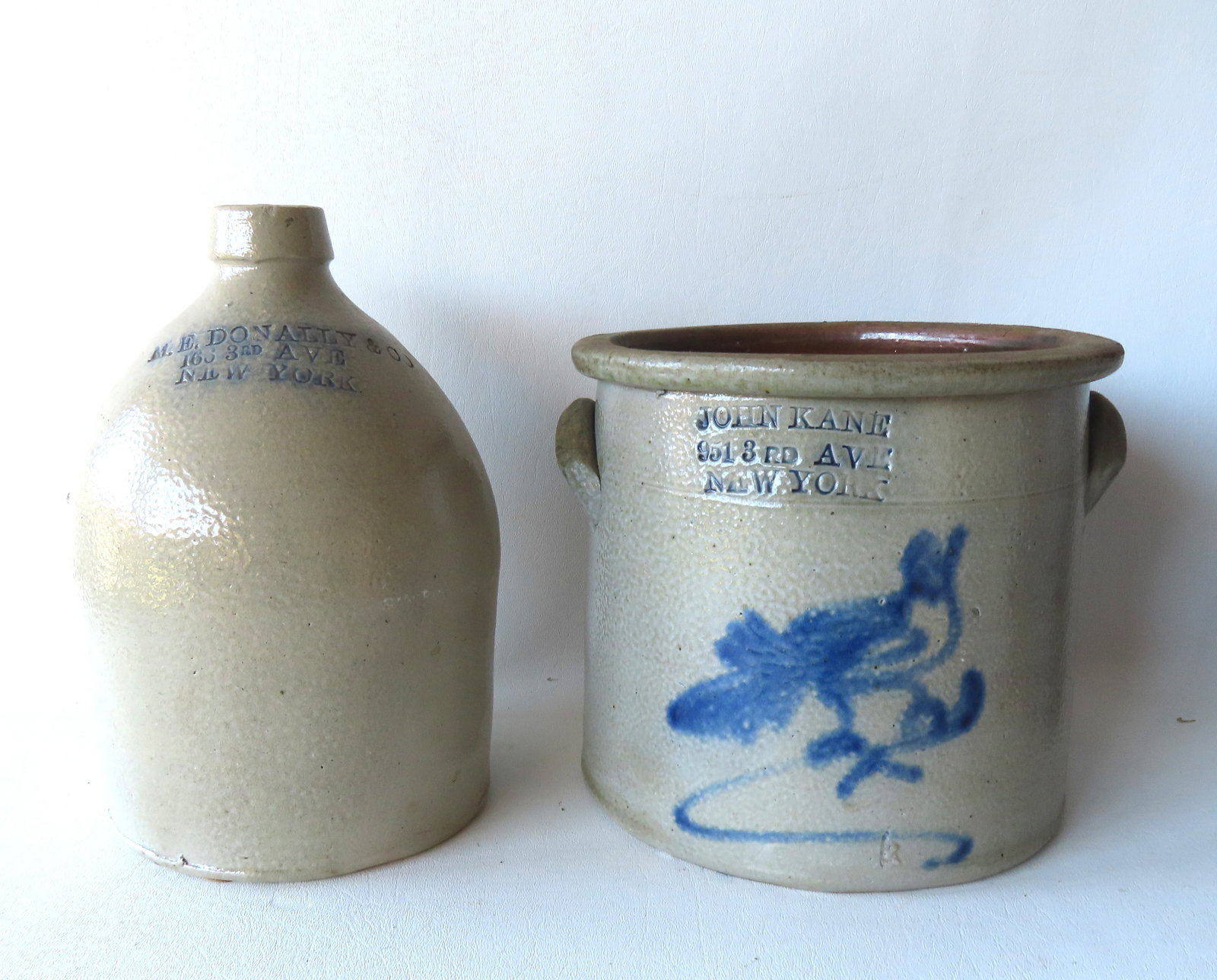 Two New York City country store crockery, both appear to be 1 gallon size or smaller, including: The: Two New York City country store crockery, both appear to be 1 gallon size or smaller, including: The first with the impressed mark of "JOHN KANE / 951 8 RD AVE. / NEW YORK", decorated with a cobalt bl