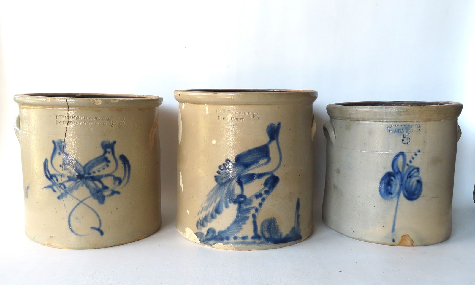 Three large damaged stoneware crocks in need of restoration - see photos for details of damage and: Three large damaged stoneware crocks in need of restoration - see photos for details of damage and losses, including: Crock, 5 gallon, stamped "RIEDINGER & CAIRE / POUGKEEPSIE N.Y." and decorated with