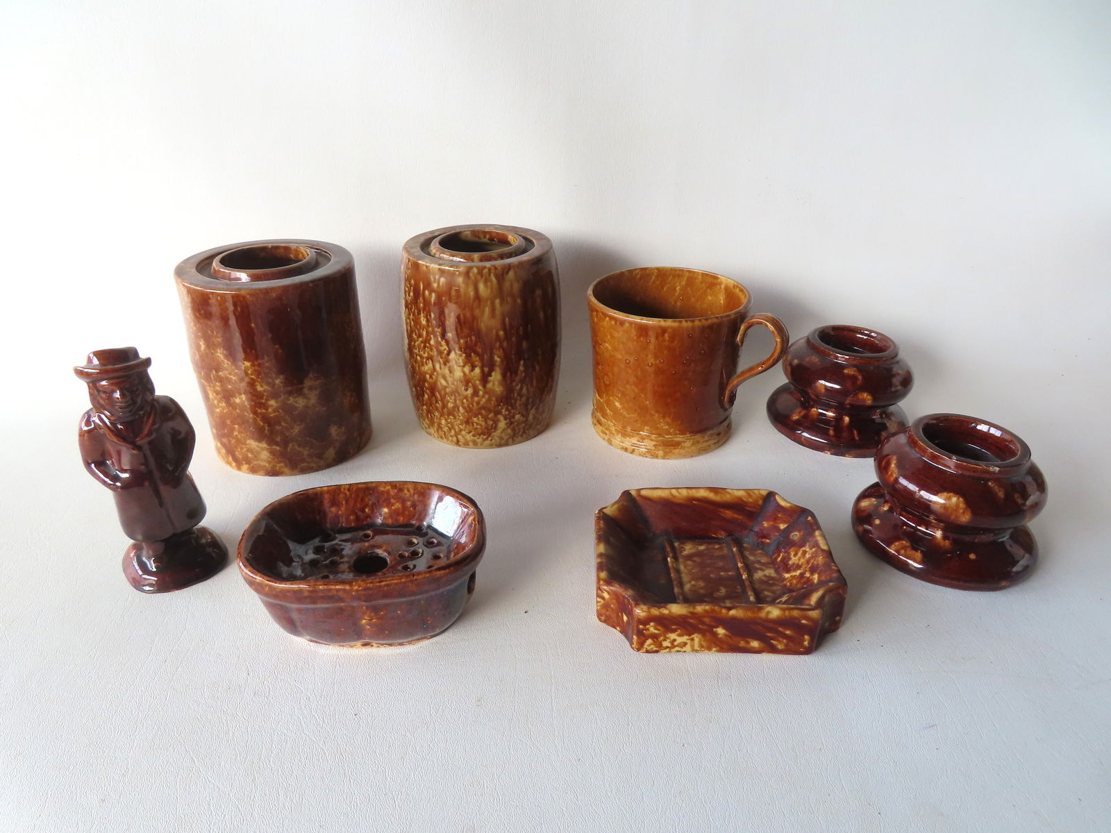 Grouping of 8 pieces of Bennington or Rockingham pottery including: 2 open jars - these are the: Grouping of 8 pieces of Bennington or Rockingham pottery including: 2 open jars - these are the largest 5 1/2"H; 2 furniture rests; a coffee mug with applied handle; 2 soap dishes, and a sugar shaker