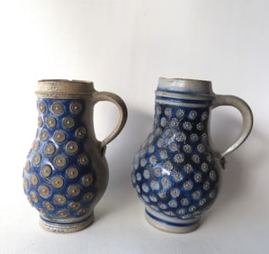 Two Westerwald stoneware tankards, lacking lids, both in brushed cobalt blue and having embossed