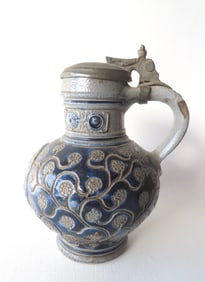 A Westerwald stoneware tankard having a design of incised flowers on vine and having embossed