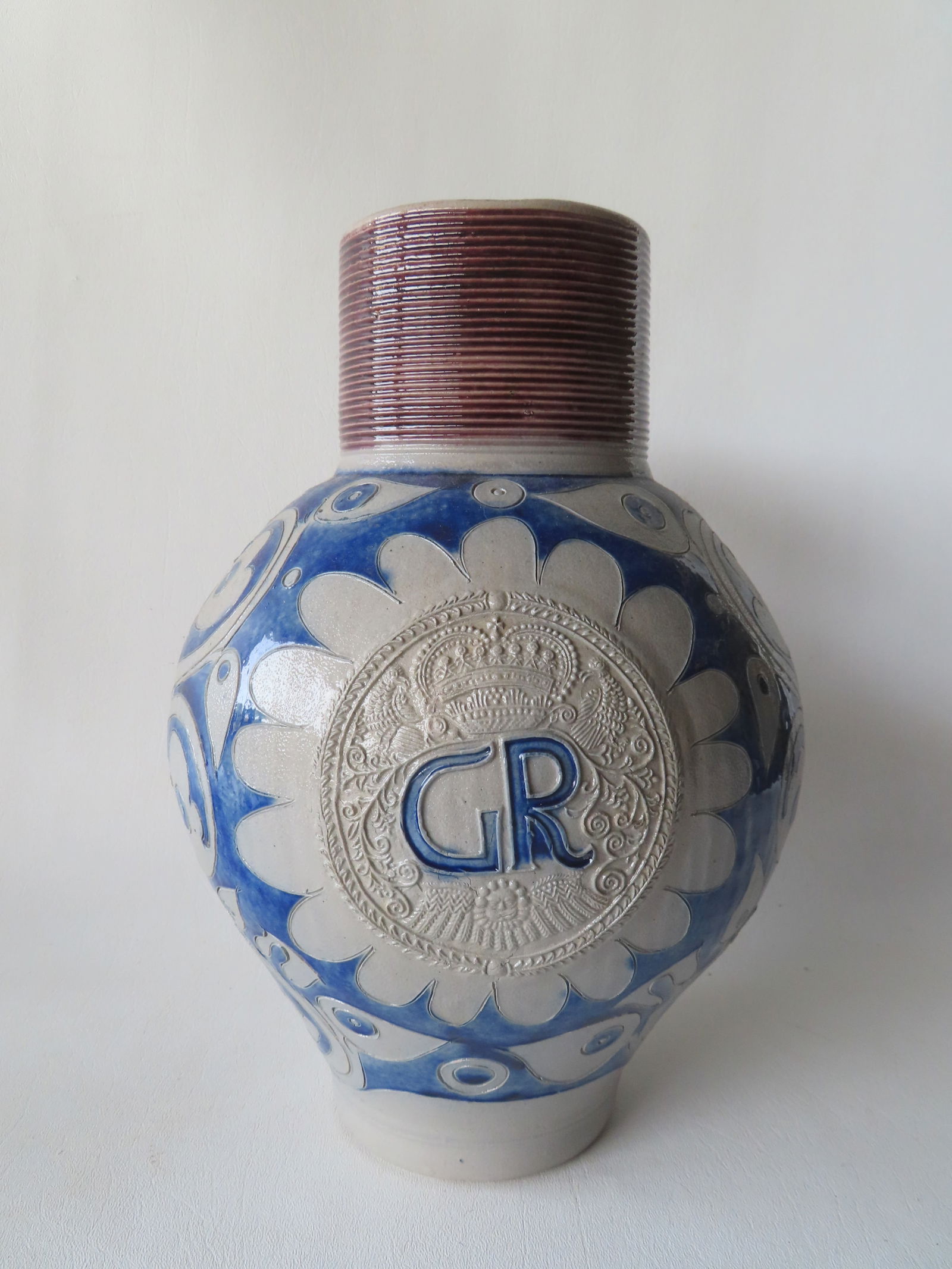 A Westerwald stoneware bulbous stoneware GR jug having a cylindrical collar decorated with incised: A Westerwald stoneware bulbous stoneware GR jug having a cylindrical collar decorated with incised concentric lines and brushed in manganese plum color, above body brushed in cobalt blue with incised