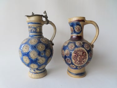 Two Westerwald stoneware jugs, both believed to be 18th century. The first, decorated with raised