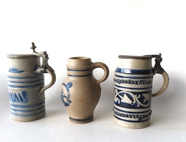 Three Westerwald stoneware tankards, all believed to be 18th century. The first of cylindrical form,