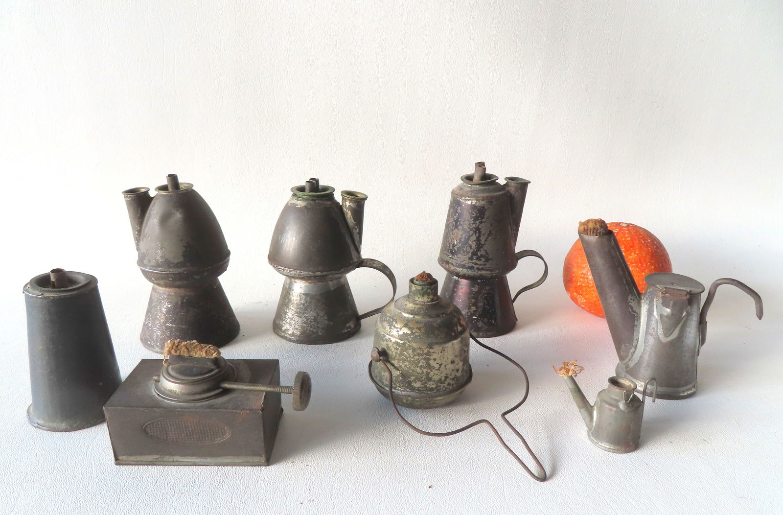 Grouping of 7 miniature tin lamps, most fat burning, 18th/19th century and in good condition.: Grouping of 7 miniature tin lamps, most fat burning, 18th/19th century and in good condition. Includes 3 petticoat lamps (one lacking finger holder), 2 with double burners, the other single burner, tr