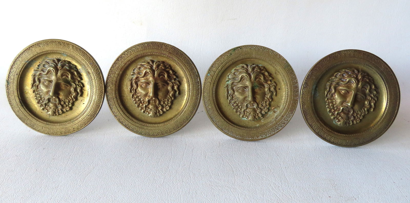 Grouping of 4 matching French bronze curtain tie-backs decorated with a raised portrait of Bacchus -: Grouping of 4 matching French bronze curtain tie-backs decorated with a raised portrait of Bacchus - marked "Made in France" on reverse side - 3 3/4" diameter x 4 3/4"D. All in good condition, early 2