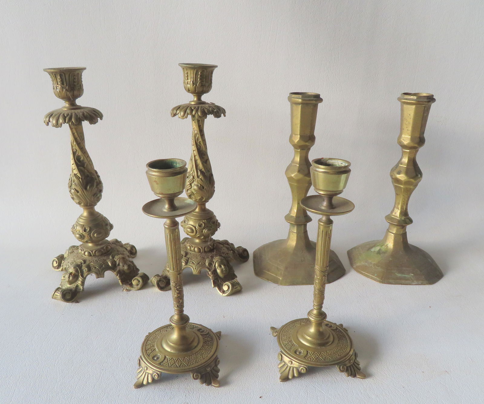 Three pair of vintage continental brass candlesticks including a pair in heavy brass with an: Three pair of vintage continental brass candlesticks including a pair in heavy brass with an acanthus twisted column leading to 4 scrolled feet with lady's faces - late 19th to early 20th century - on