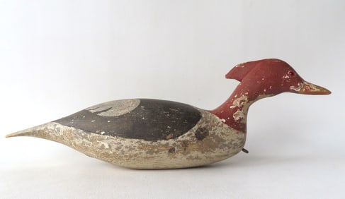 A swimming Merganser decoy, weathered original paint, glass eyes, carved wings, and offset lead