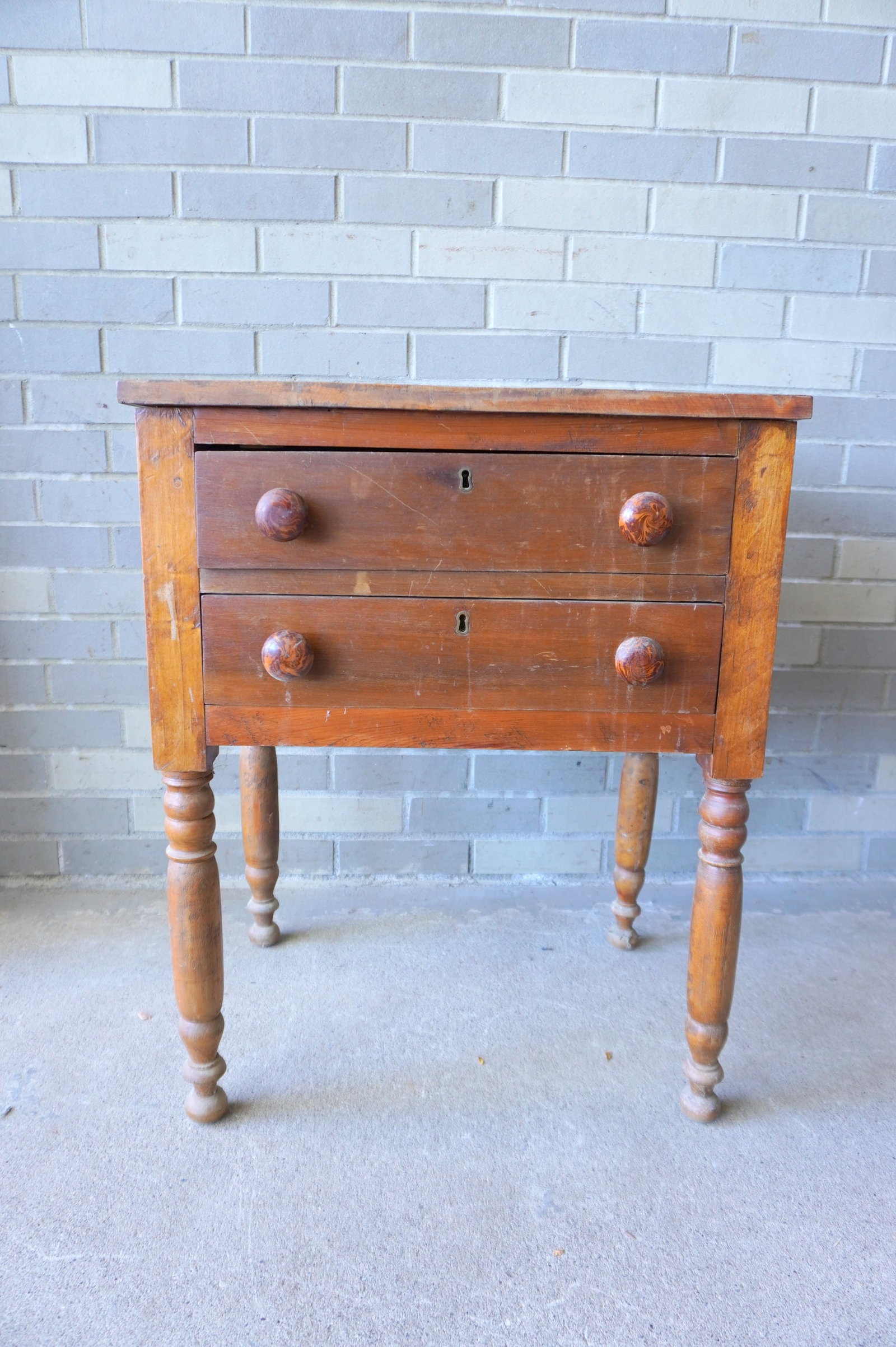 A Sheraton poplar wood 2 drawer stand with original grain painted Bennington pulls, circa 1830, the: A Sheraton poplar wood 2 drawer stand with original grain painted Bennington pulls, circa 1830, the original top likely 1 board. Structurally sound, but has scratched surface top and needs cleaning. M