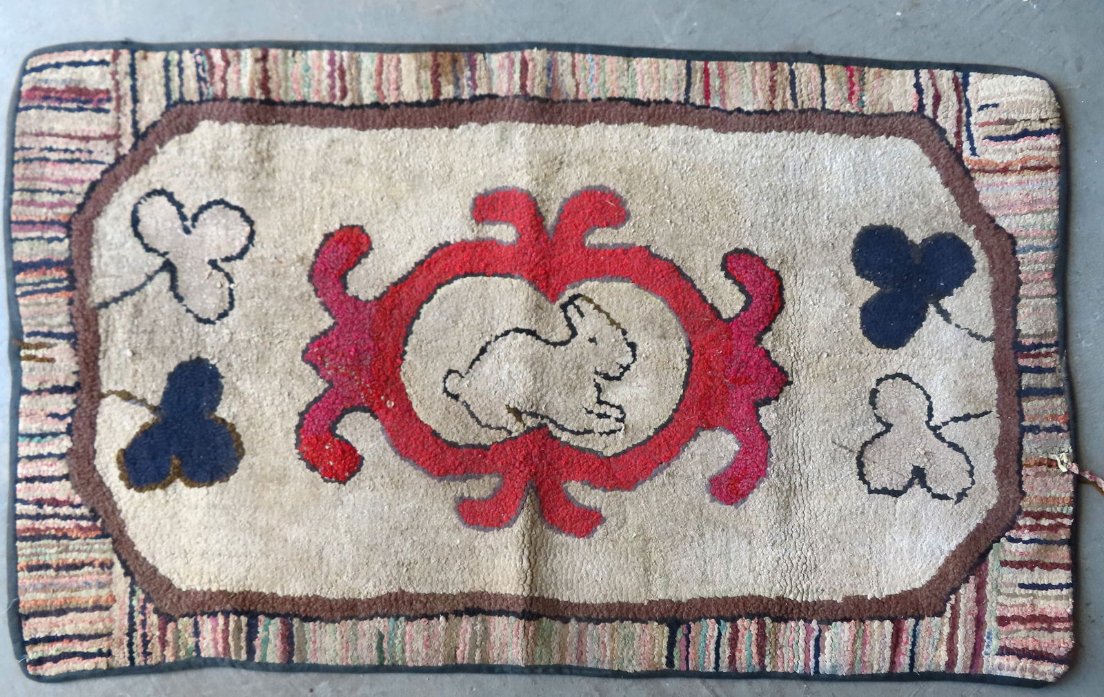 A primitive hooked rug having a central image of a rabbit within medallion - minor wool pulls and: A primitive hooked rug having a central image of a rabbit within medallion - minor wool pulls and overall good condition. Measures 44" x 26".