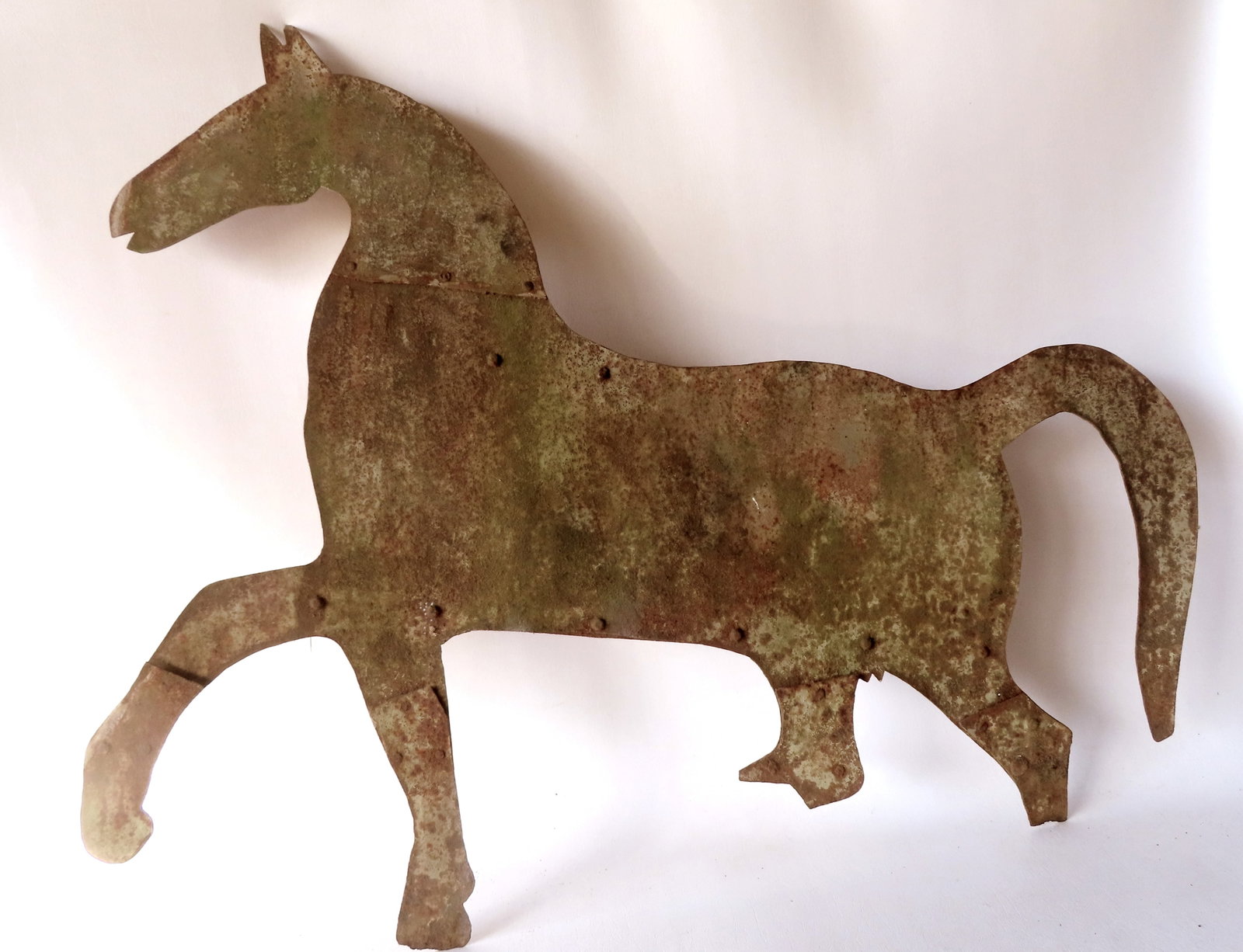 A silhouette sheet iron horse weathervane, early 19th century - measures 38"L x 32 1/2"H. Traces of: A silhouette sheet iron horse weathervane, early 19th century - measures 38"L x 32 1/2"H. Traces of original paint, but with losses that include losses and repairs to feet.