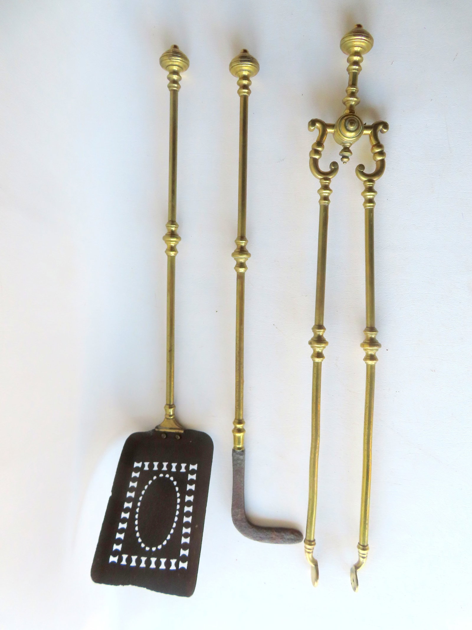 Three matching hand made brass and iron fireplace tools, including shovel with pierced blade, tongs: Three matching hand made brass and iron fireplace tools, including shovel with pierced blade, tongs and poker with hand forged iron stoker at base,19th century - very good condition. The largest 29"L.