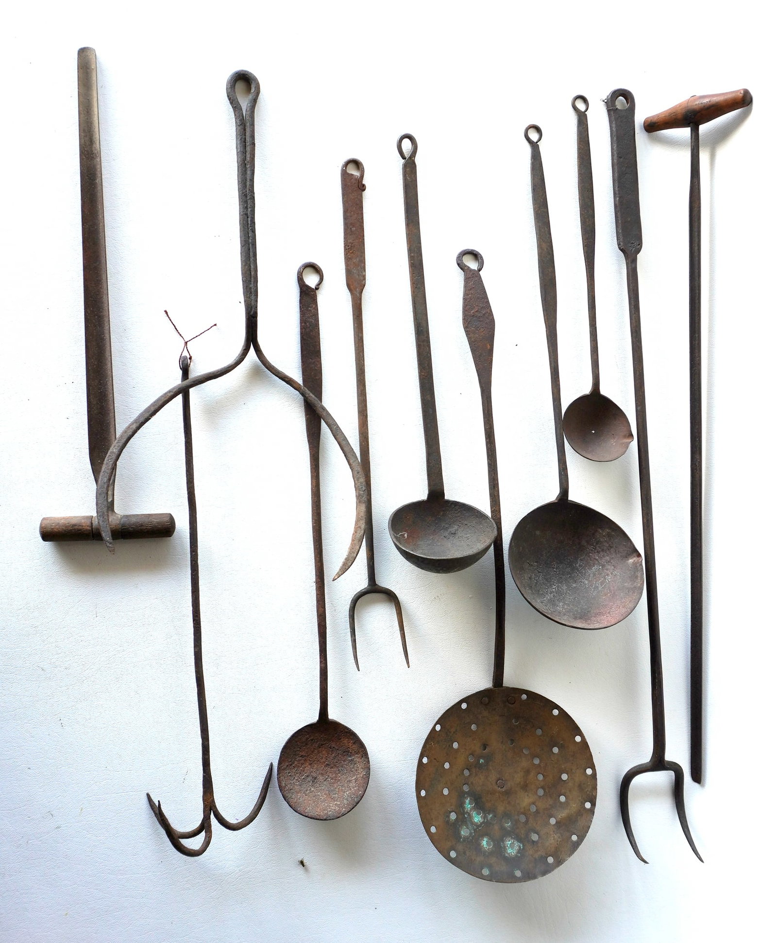 Grouping of 11 mostly hand forged iron kitchen tools including ladles, forks, pie lifter, strainer,: Grouping of 11 mostly hand forged iron kitchen tools including ladles, forks, pie lifter, strainer, forks, etc. Most in good condition. The largest measures