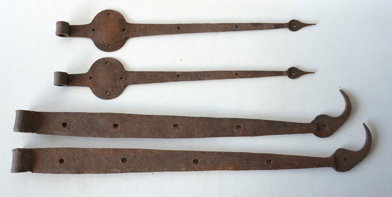 Two matched pairs of 18th century door hinges. The first, a pair of Dutch hinges with arrow-head: Two matched pairs of 18th century door hinges. The first, a pair of Dutch hinges with arrow-head finials, in very good condition - 21 3/8"L x 3 5/8"W; the second pair, with ball and hook finials, meas