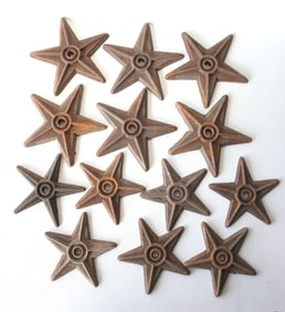 Grouping of 13 cast iron star shaped building anchors, some with surface rust, but overall in good