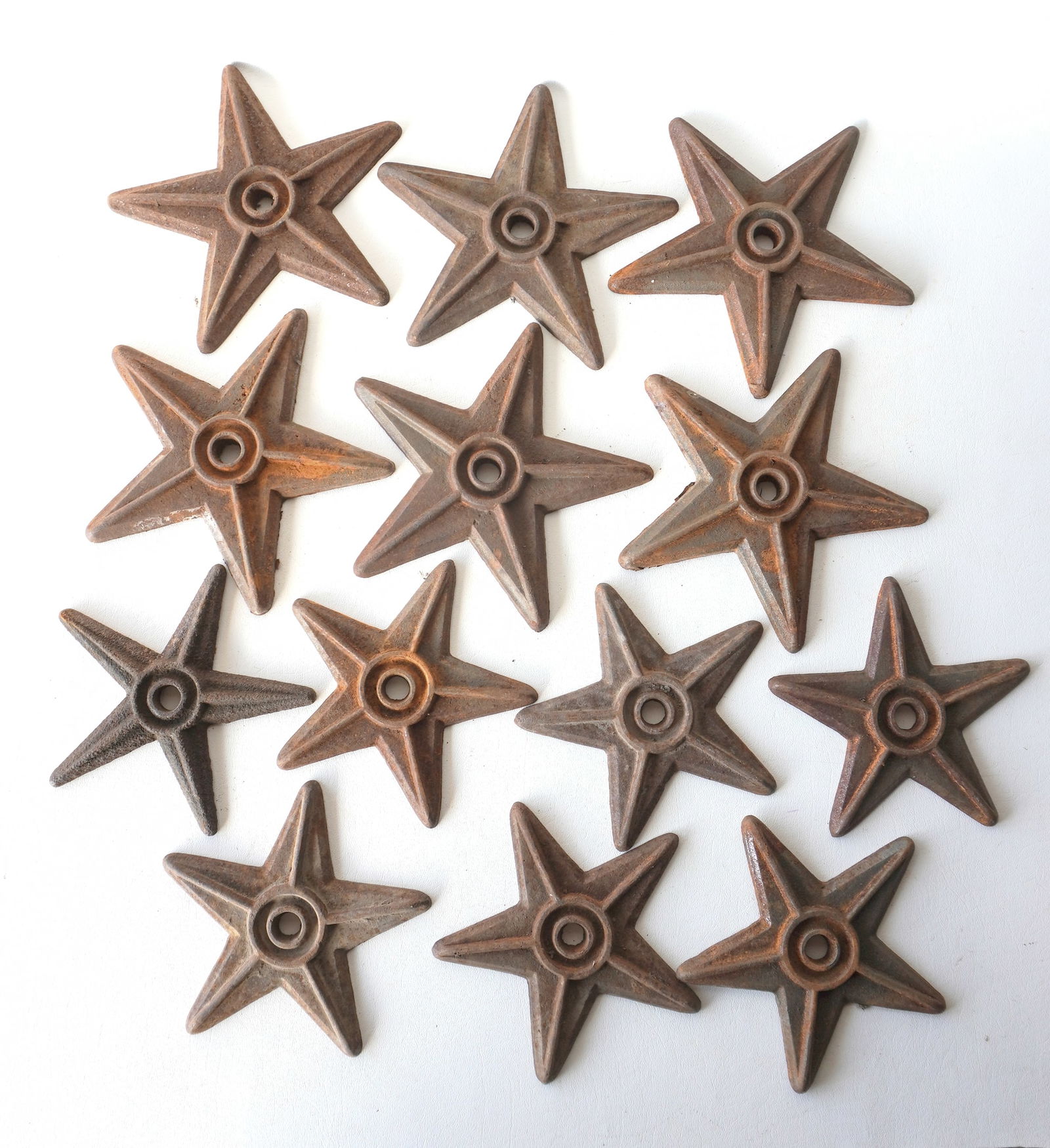 Grouping of 13 cast iron star shaped building anchors, some with surface rust, but overall in good: Grouping of 13 cast iron star shaped building anchors, some with surface rust, but overall in good condition. Grouping of 6 measures 8 3/8" diameter and group of 7 measures 7" diameter. Provenance: Fr