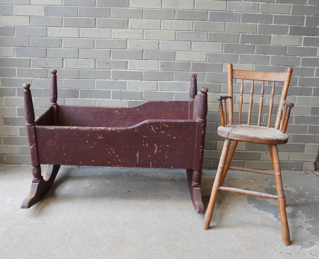 An 18th century child's cradle in old brown paint with use wear - measures 36 1/2"L x 26 1/2"W x 27: An 18th century child's cradle in old brown paint with normal use wear and in good condition - measures 36 1/2"L x 26 1/2"W x 27 1/2"H; and a child's high chair with spindle back, worn saddle seat, an