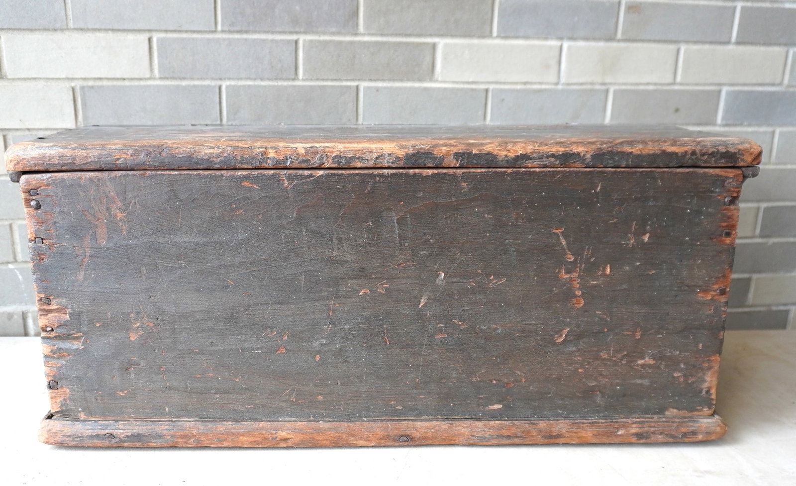 A primitive 18th century small size blanket box in original green paint with cotterpin hinges,: A primitive 18th century small size blanket box in original green paint with cotterpin hinges, rosehead nail construction, molded edge to lid, and molded base - hairlines in lid with typical use wear 