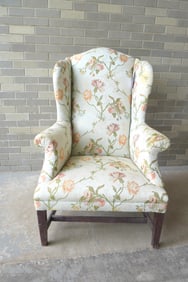 A Hepplewhite style wing chair with stretcher base, probably early 20th century. The upholstery with