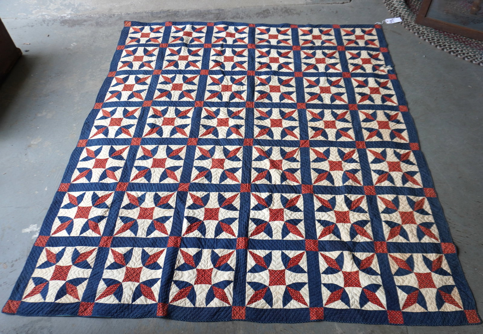 Two patchwork quilts.: Two patchwork quilts.The first,a very fine hand stitched applique quilt in the Wandering Foot pattern, with red, white and blue fabric suggesting American patriotism - small irregular hole on one edge